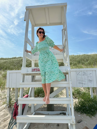 Women standing on beach while wearing dress