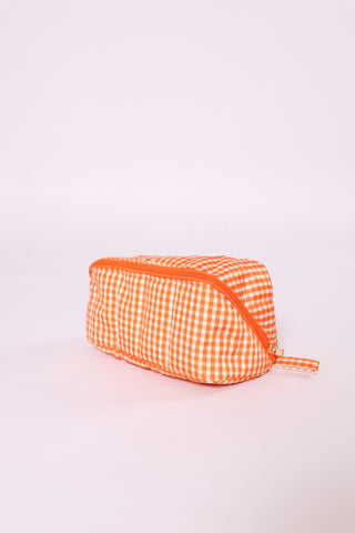 Bright orange gingham glam toiletry and makeup bag with zipper closure.