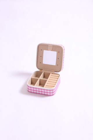 Pink gingham jewelry case shown open with built-in mirror and divided compartments.