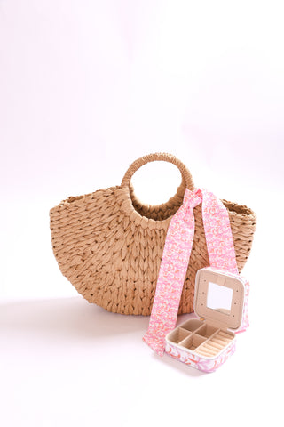 Woven straw handbag accessorized with pink coral twillie and jewelry case.