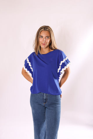 Ziggy Shirt in royal blue with flowy sleeves and white wavy trim details