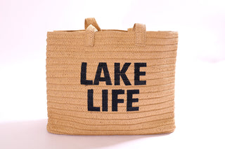Palma Tote Bag made from eco-friendly straw, featuring bold black embroidered “LAKE LIFE” text.
