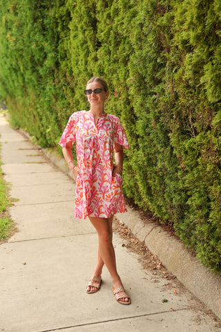 Lifestyle photo of Romy Mini Dress in watercolor leaf print, styled outdoors for summer wear.