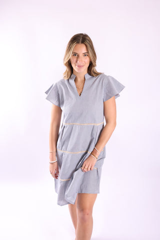 Woman modeling blue-and-white striped Joie Dress with flutter sleeves and v-neck in a studio setting.