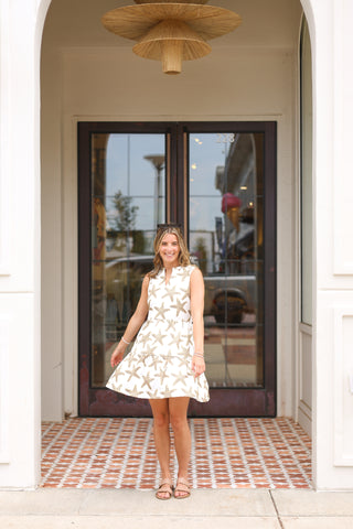 Lifestyle image of Maddie Dress in pink starfish print, styled for summer outings.