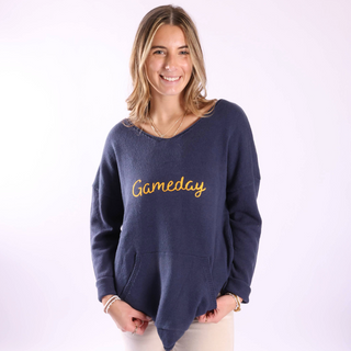 Woman wearing a navy blue sweater with 'Gameday' in yellow on a white background