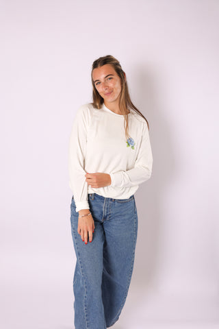Seasonal Stitch Top featuring blue hydrangea embroidery, paired with denim jeans.
