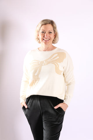 Cream long sleeve sweater with gold bow printed across the front
