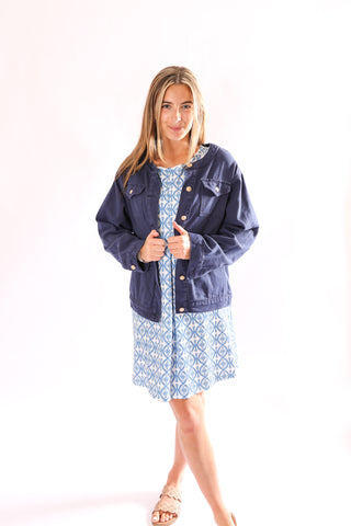 Model in Coco Jean Jacket dark wash version, paired with a blue patterned dress.