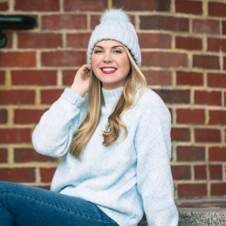 Light blue cable knit beanie hat with pom pom