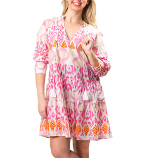 Orange, cream, and pink abstract tiered long sleeve tunic dress with a split neck and tassel ties