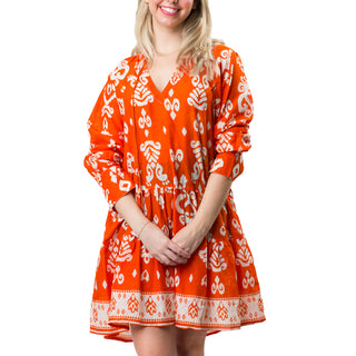 Orange and white paisley pattern tiered long sleeve tunic dress with a split neck and tassel ties