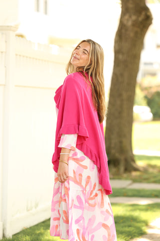 Pink and coral abstract print Diane Dress styled with a hot pink wrap, lifestyle outdoor photo