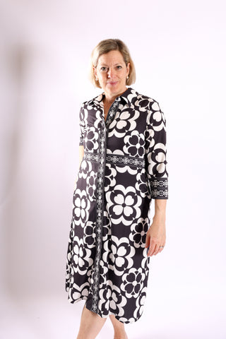 Woman modeling The Lennon Dress in black and white floral print, front view highlighting waist detail.