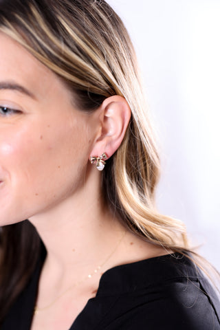woman wearing gold bow earrings with a pearl