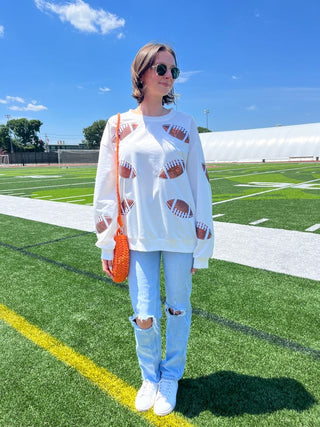 lifestyle shot of white crewneck with sequins footballs 