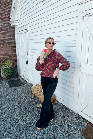 woman wearing camel fluffy mittens while holding a coffee cup