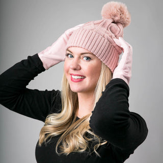 Light pink Karen cable knit beanie hat with coordinating pom pom with light pink herringbone texting gloves