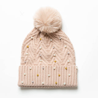 Blush knit hat with pom-pom decorated with pearls and gold balls.