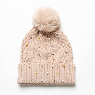 Blush knit hat with pom-pom decorated with pearls and gold beads.