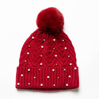 Red knit hat with pom-pom decorated with pearls and gold beads.
