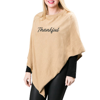 Tan knit poncho with Thankful in black script lettering 