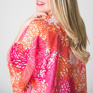 close up shoulder view of Pink Sea Coral patterned one size, 100% polyester, lightweight poncho