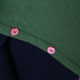 close up of green poncho with peppermint candy button trim
